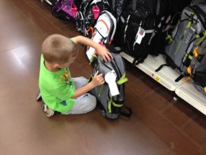 Checking out all pockets before deciding on the best backpack.
